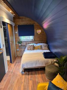 a bedroom with a bed and a blue wall at Portside Pasture - (Luxury Cabin) in Portpatrick