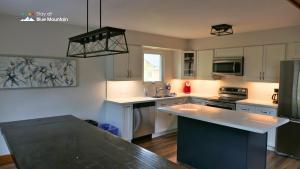 a kitchen with white cabinets and a black counter top at Summit Ridge 3 in Blue Mountains