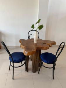 a wooden table with two chairs and a vase on top at habitación cerca a playa man in San Cristobal