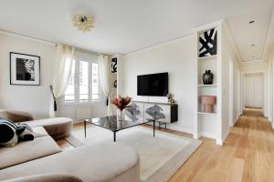 a living room with a couch and a table at Sumptuous apartment with terrace Courbevoie in Courbevoie