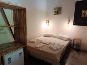 um pequeno quarto com uma cama com toalhas em Aruá Observação de aves e natureza em Praia do Forte