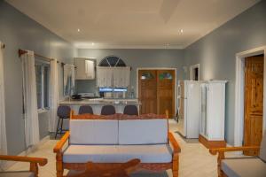 a living room with a couch and a kitchen at Majestic Ridge Villas in Soufrière