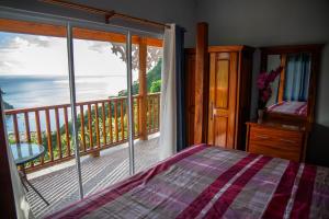 a bedroom with a view of the ocean from a balcony at Majestic Ridge Villas in Soufrière