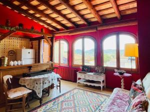 una sala de estar con paredes y ventanas de color rojo. en La Morada Del Unicornio, en Calonge