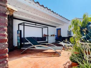 un patio con una silla y un sofá en La Morada Del Unicornio, en Calonge