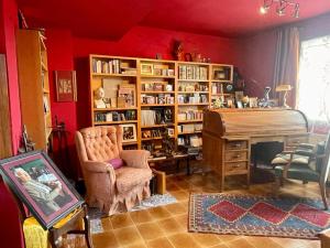 una sala de estar con un piano y un estante de libros en La Morada Del Unicornio, en Calonge