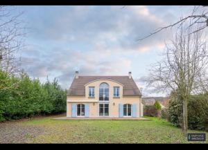 uma casa branca com um telhado castanho em Maison individuelle proche Paris / Versailles em Villennes-sur-Seine