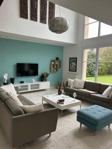 a living room with two couches and a tv at Maison individuelle prVersailles in Villennes-sur-Seine