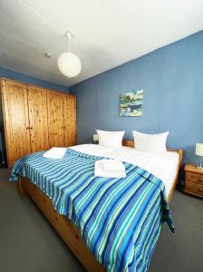 a bedroom with a large bed with a blue wall at Ferienhaus Zum Lochstein - FW Kornboden in Sankt Andreasberg