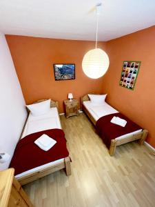 two beds in a room with orange walls at Ferienhaus Zum Lochstein - FW Kornboden in Sankt Andreasberg