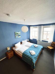 a blue bedroom with a bed with two towels on it at Ferienhaus Zum Lochstein - FW Kornboden in Sankt Andreasberg
