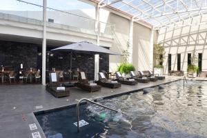 - une piscine avec des chaises et un parasol dans un bâtiment dans l'établissement Gran Hotel de Puebla by HNF, à Puebla