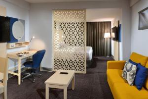 una camera d'albergo con divano giallo e scrivania di Gran Hotel de Puebla by HNF a Puebla