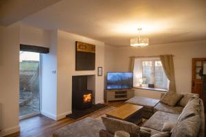 a living room with a couch and a fireplace at Hycemoorside House in Millom