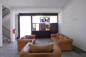 a living room with brown leather couches and a window at Hotel Villa 12 TX in Tequisquiapan