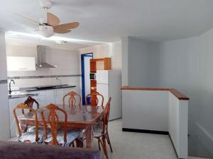 una cucina con tavolo, sedie e frigorifero di Apartamento en Los Nietos con piscina comunitaria. a Los Nietos