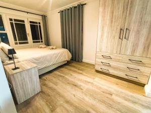 1 dormitorio con 1 cama, vestidor y ventana en Sunny Side Apartment, en Knysna