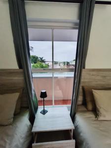 a small lamp sitting on a table in front of a window at Sunny Side Apartment in Knysna