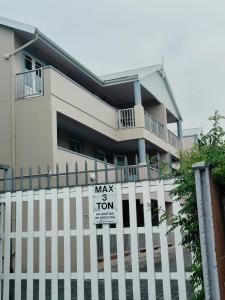 a sign on a fence in front of a house at Sunny Side Apartment in Knysna