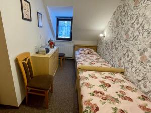 1 Schlafzimmer mit 2 Betten, einem Schreibtisch und einem Fenster in der Unterkunft Ferienwohnungen Marianne Lau in Wernigerode