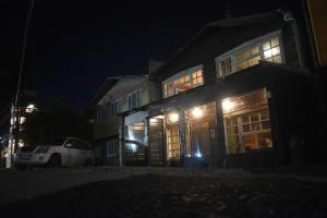 a house with a car parked in front of it at night at Estación Hostel in Castro