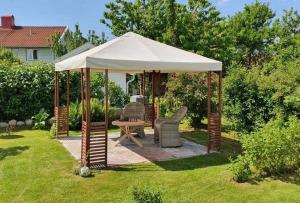 a gazebo with chairs and a table in a yard at Lägenhet Fjällbacka in Fjällbacka