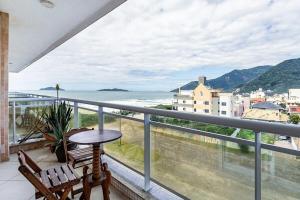 uma varanda com mesa e cadeiras e vista para o oceano em Duplex vista para o mar na praia dos Açores em Florianópolis