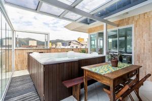 uma grande casa de banho com uma banheira e uma mesa em Duplex vista para o mar na praia dos Açores em Florianópolis