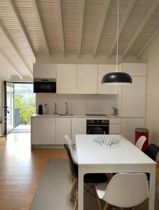 蓬蒂達巴爾卡的住宿－Casa dos Cortelhas，厨房配有白色的餐桌和椅子