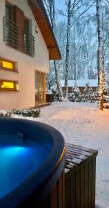 a hot tub in front of a house in the snow at Mazursko - domy in Kretowiny