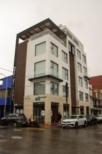 een hoog wit gebouw met auto's geparkeerd voor het bij HOTEL DEL CARMEN in Zitácuaro