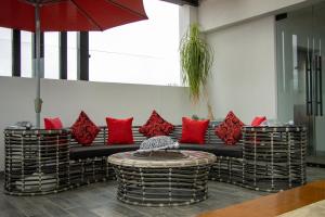 Zitácuaro的住宿－HOTEL DEL CARMEN，客房设有一张带红色枕头的沙发和一张桌子。