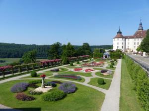 un jardin en face d'un grand bâtiment blanc dans l'établissement Apartment Schloßblick, à Langenbourg