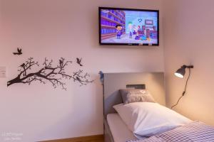 1 dormitorio con 1 cama y TV en la pared en Ferienhaus Taubenhof, en Simprechtshausen