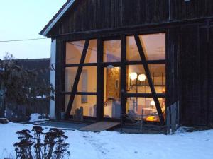 una grande finestra di una casa nella neve di Ferienhaus ScheunenRefugio a Rot am See