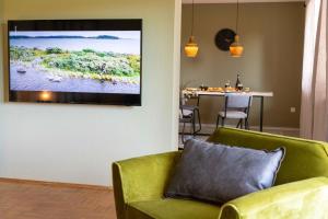 Niederstetten的住宿－Haus Grün，客厅配有绿色沙发和墙上的电视