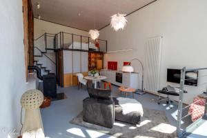 een woonkamer met een trap en een kamer met een tafel bij Ferienhaus ScheunenRefugio in Rot am See