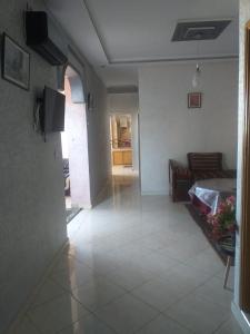 uma sala de estar com uma cama e piso em azulejo em Appartement meublé situé a côté de centre ville em Meknès
