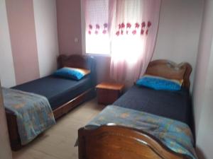 um quarto com 2 camas e uma janela em Appartement meublé situé a côté de centre ville em Meknès