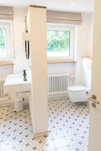 a bathroom with a white toilet and a sink at Haus Grün in Niederstetten