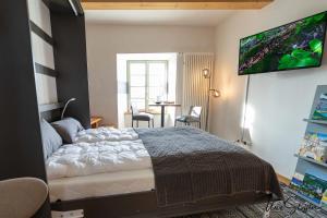 1 dormitorio con 1 cama y TV de pantalla plana en Ferienwohnung Türmerwohnung, en Öhringen