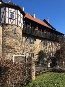 a stone building with a balcony on top of it at Ferienwohnung Türmerwohnung in Öhringen
