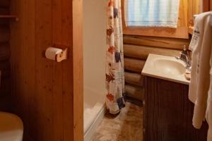 a bathroom with a sink and a toilet paper roll at Experience Montana - Seasonal Cabins #2, 3, 4 & 5 in Bigfork +20 photos