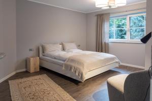 een witte slaapkamer met een bed en een raam bij Schmalfelden No 95 