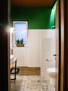 a green and white bathroom with a toilet and a window at vaya_living in Ktistádes