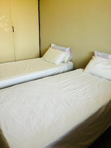 two beds sitting next to each other in a room at Gardenlea in Durban