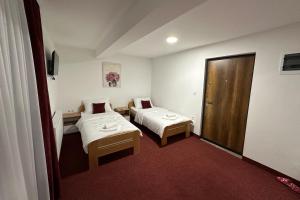 una habitación de hotel con 2 camas y una puerta en Hotel Muška voda en Kladanj