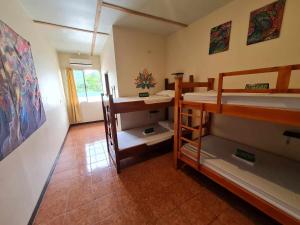 a room with two bunk beds and a hallway at Slow Monkey Hostel in Santa Teresa Beach