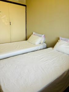 two beds sitting next to each other in a room at Gardenlea in Durban