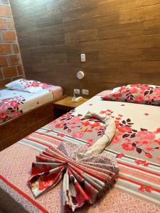 Hostal El Paraiso في Jamundí: غرفة بسريرين مع بطانيه بالقوس